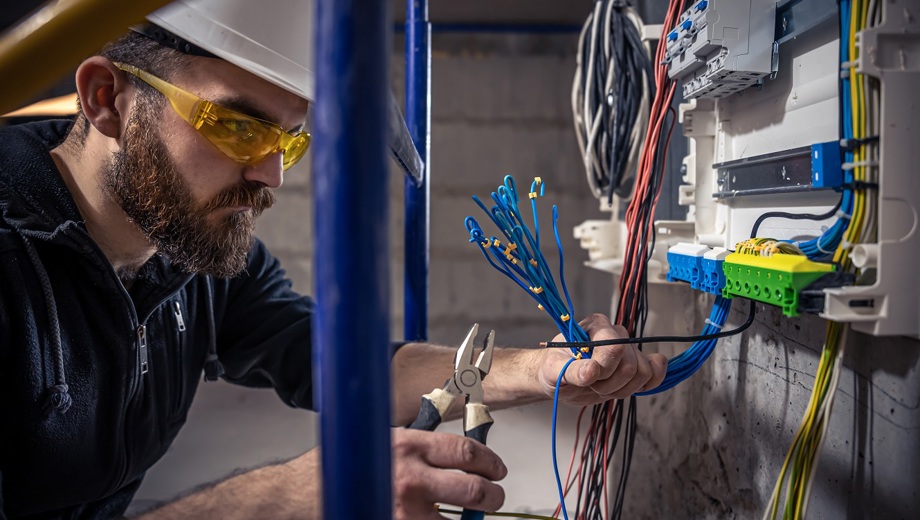 135 Male Electrician Works Switchboard With Electrical Connecting Cable Verkleinert