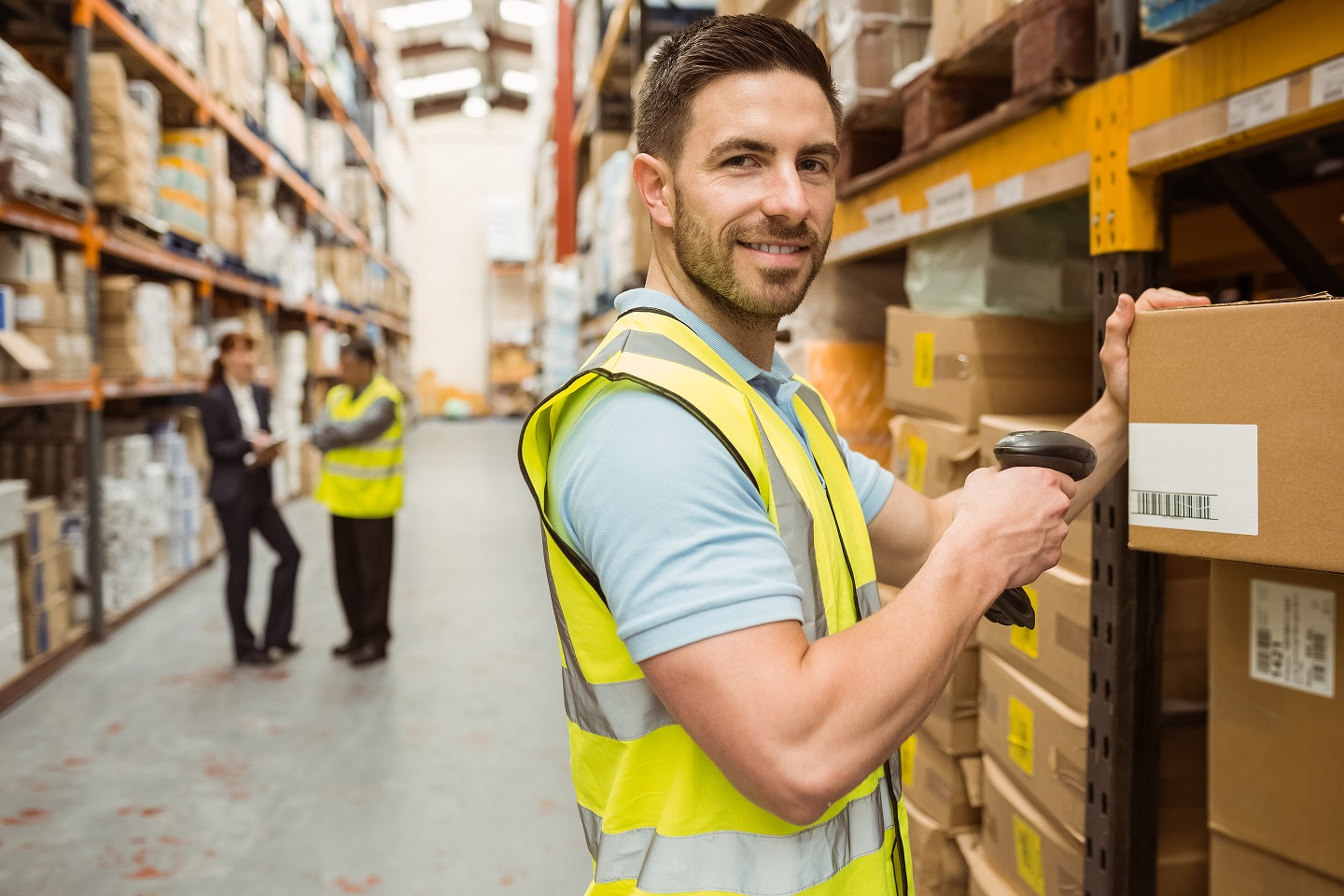 147 Warehouse Worker Scanning Box While Smiling Camera Verkleinert